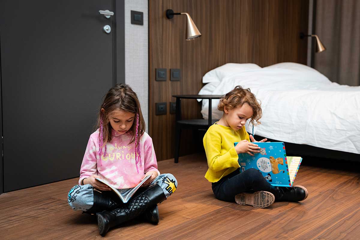 family hotel torino Hotel Duparc: bambine leggono sedute per terra vicino al letto