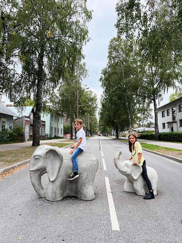due bambini in grippa due elefantini in cemento in una strada di Panu in Estonia