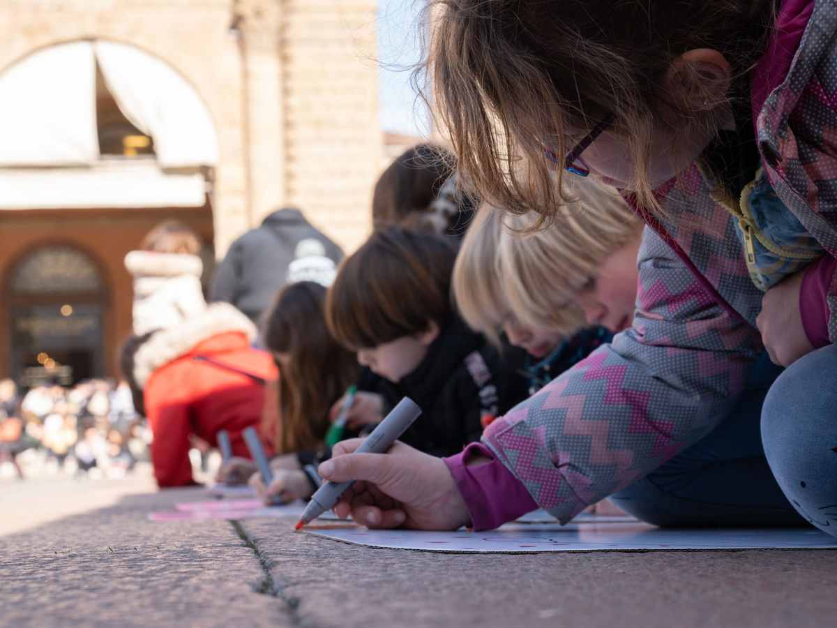 bambini che disegnano in piazza maggiore a Bologna durante un evento di Fondazione Golinelli