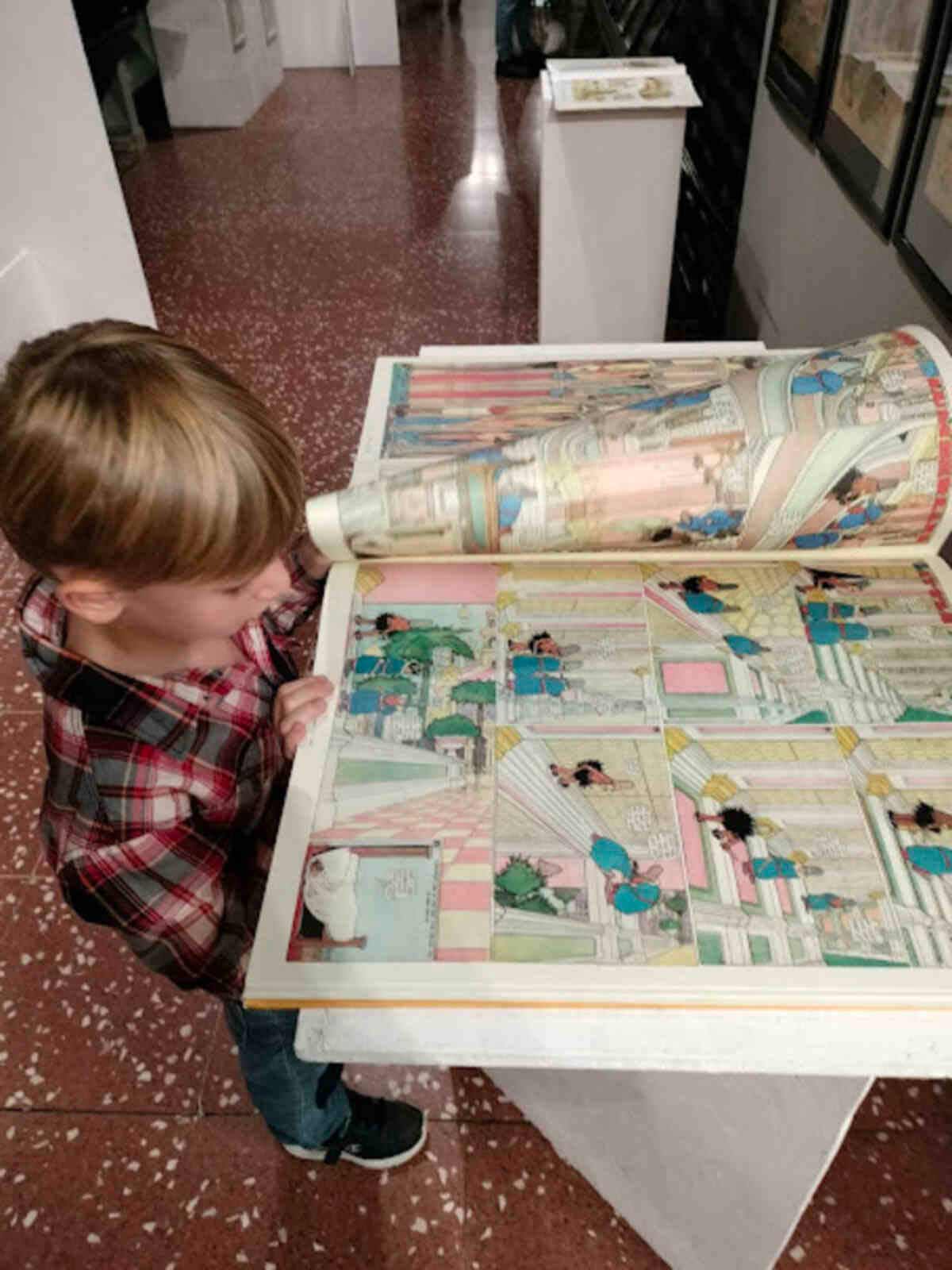 bambino sfoglia un fumetto al. mufant museo fantascienza Torino