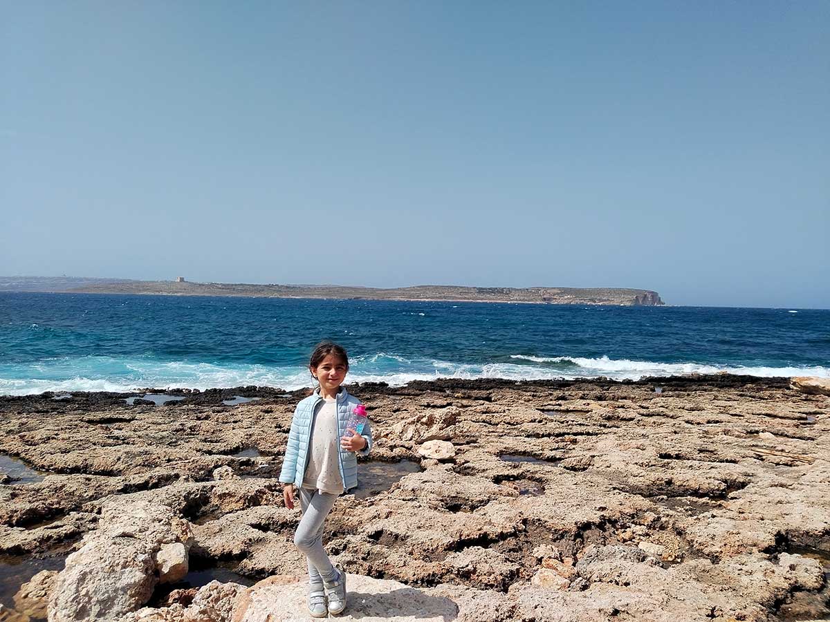 Bambina sugli scogli della costa del nord di Malta