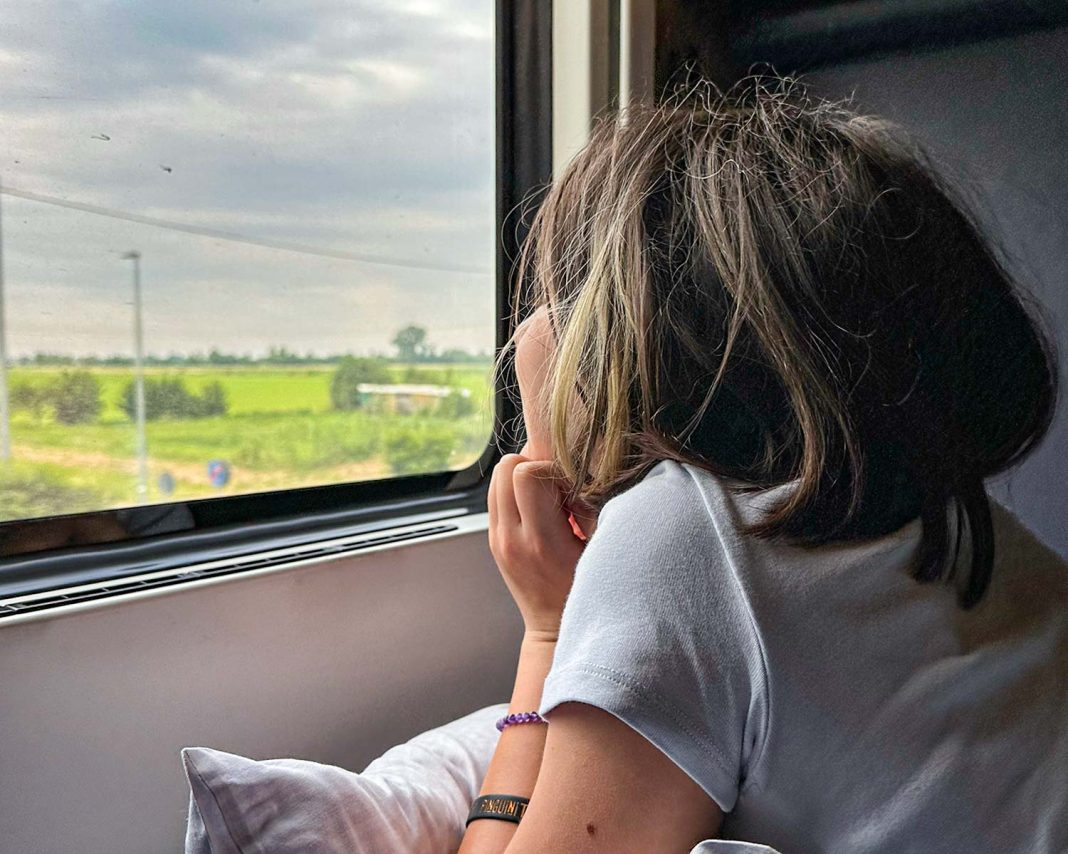 bambina guarda fuori del finestrino sul treno notturno