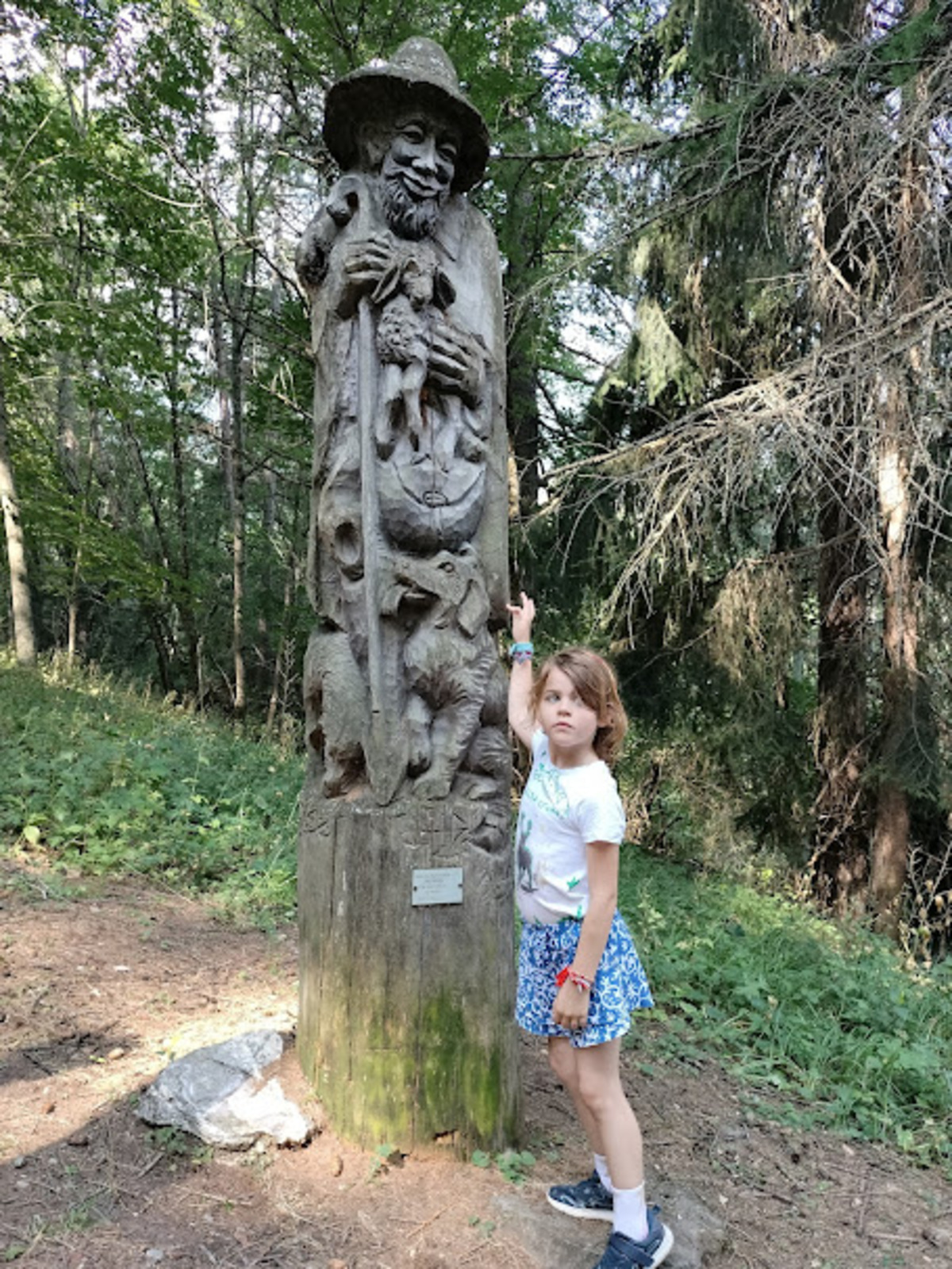 sentiero 14 sauze d'oulx val di susa bambina davanti a una statua di legno
