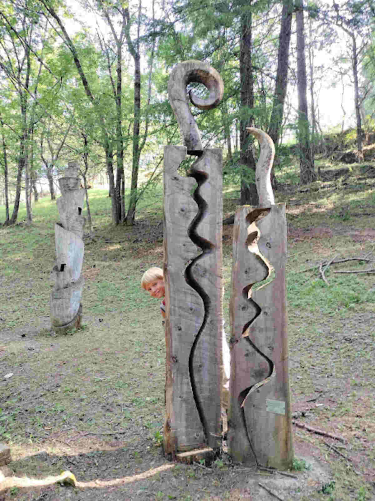 sentiero 14 sauze d'oulx val di susa bambino dietro ad una statua di legno