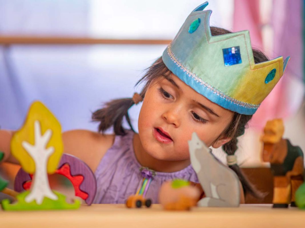 bambina con corona da regina gioca