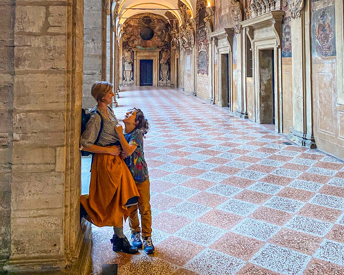 Mamma e bambino sotto i portici del Pavaglione a Bologna