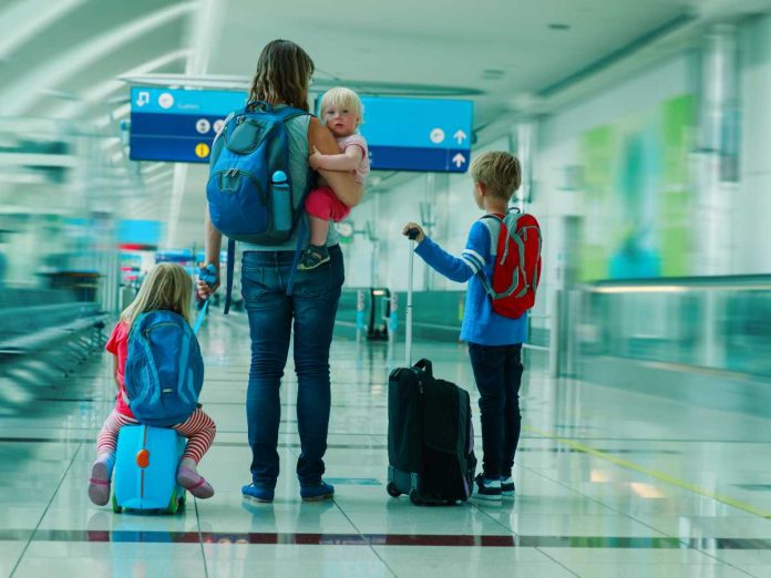 mamma con tre figli in aeroporto in partenza