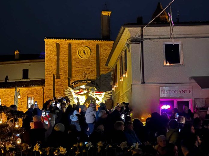 candelara-mercatini-natale-trampoliere-buio trampolieri con costumi illuminati durante lo spegnimento delle luci a candele a candelara