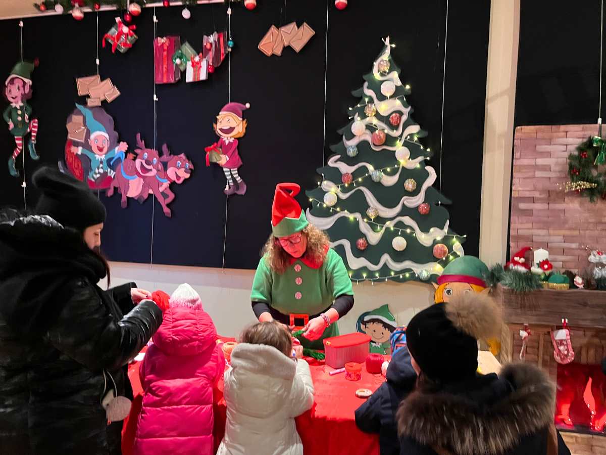 elfo con bambini per laboratorio a candelara durante i mercatini di natale