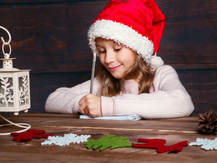 bambina scrive la letterina a babbo natale