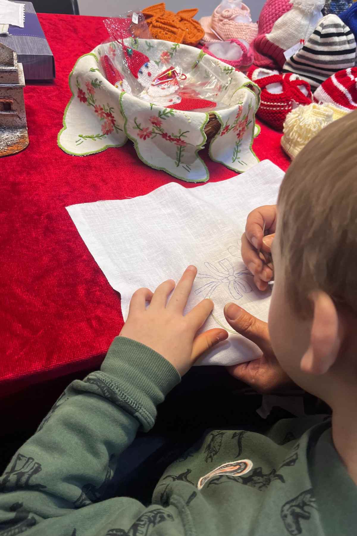 bimbo impara a cucire durante il laboratorio di ricamo al Natale a Mombaroccio