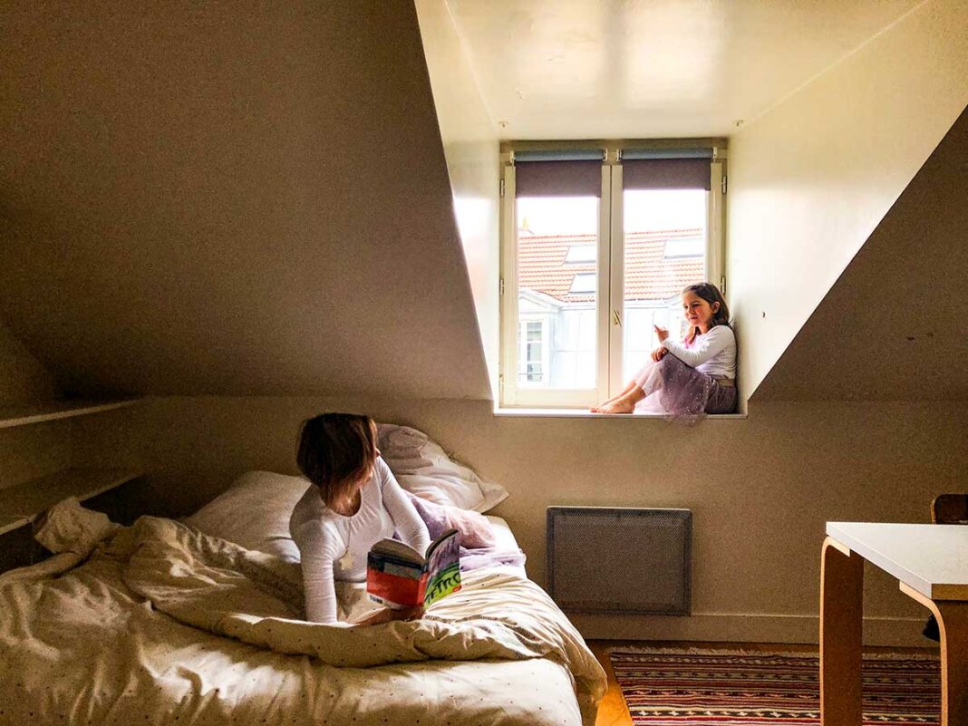 Dove dormire a Parigi con i bambini: mamma e bimba in una stanza sui tetti della città