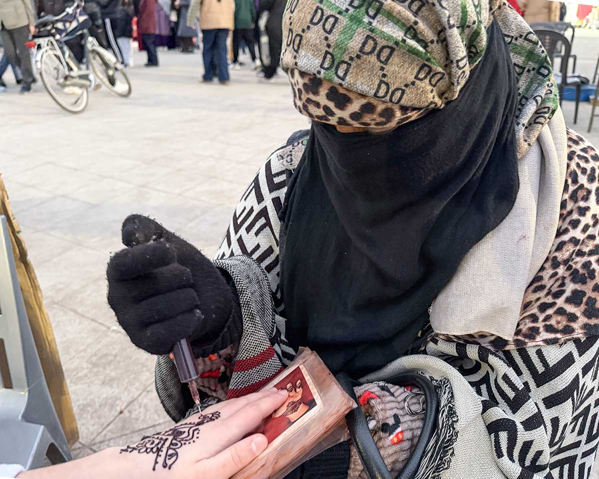 Marrakech Jemaa el-Fnaa, donna dipinge la mano ocn henne