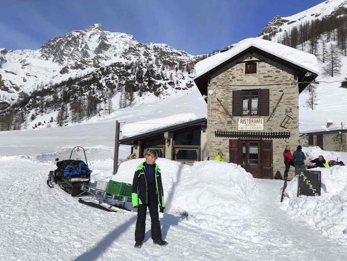 Bambino davanti al ristorante Il Bricco a Balme