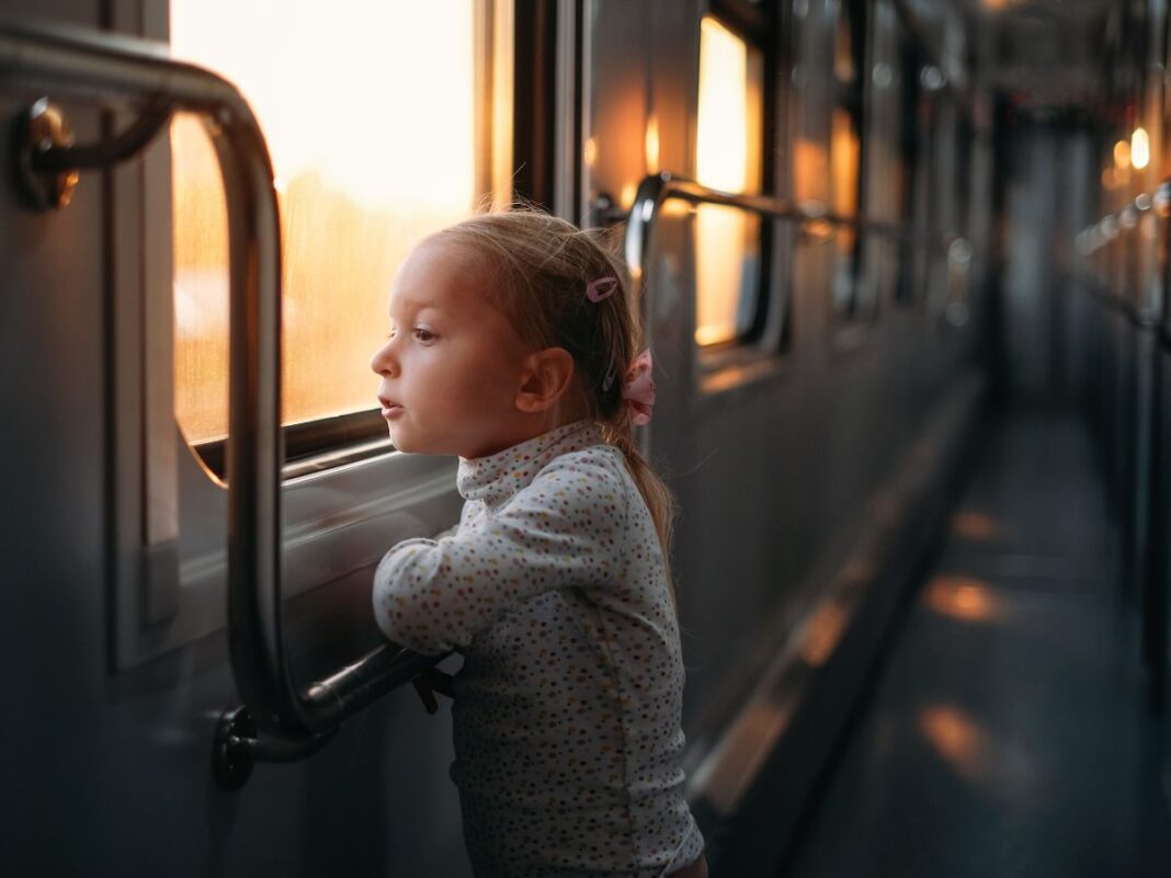 bambina guarda dal finestro in treno durante una gita d'autunno